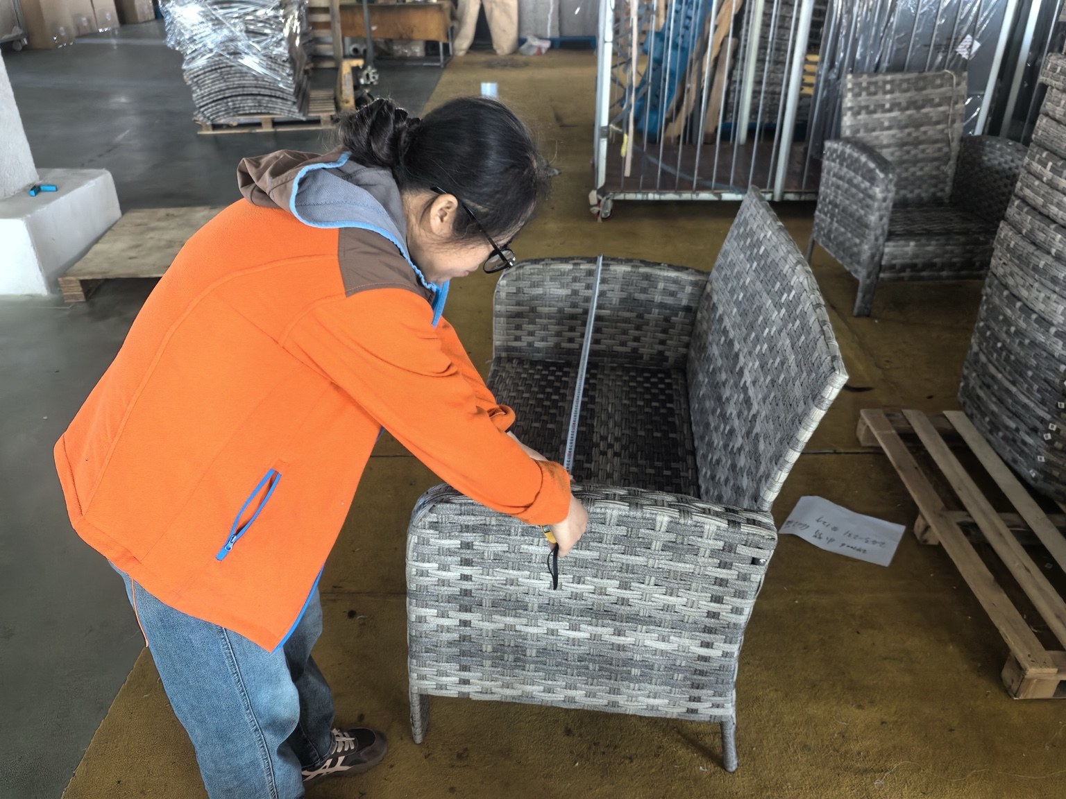 A SMART team member measuring the seat dimensions of a woven outdoor chair in the workshop